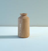 Small vase made from London plane on pale surface and grey background