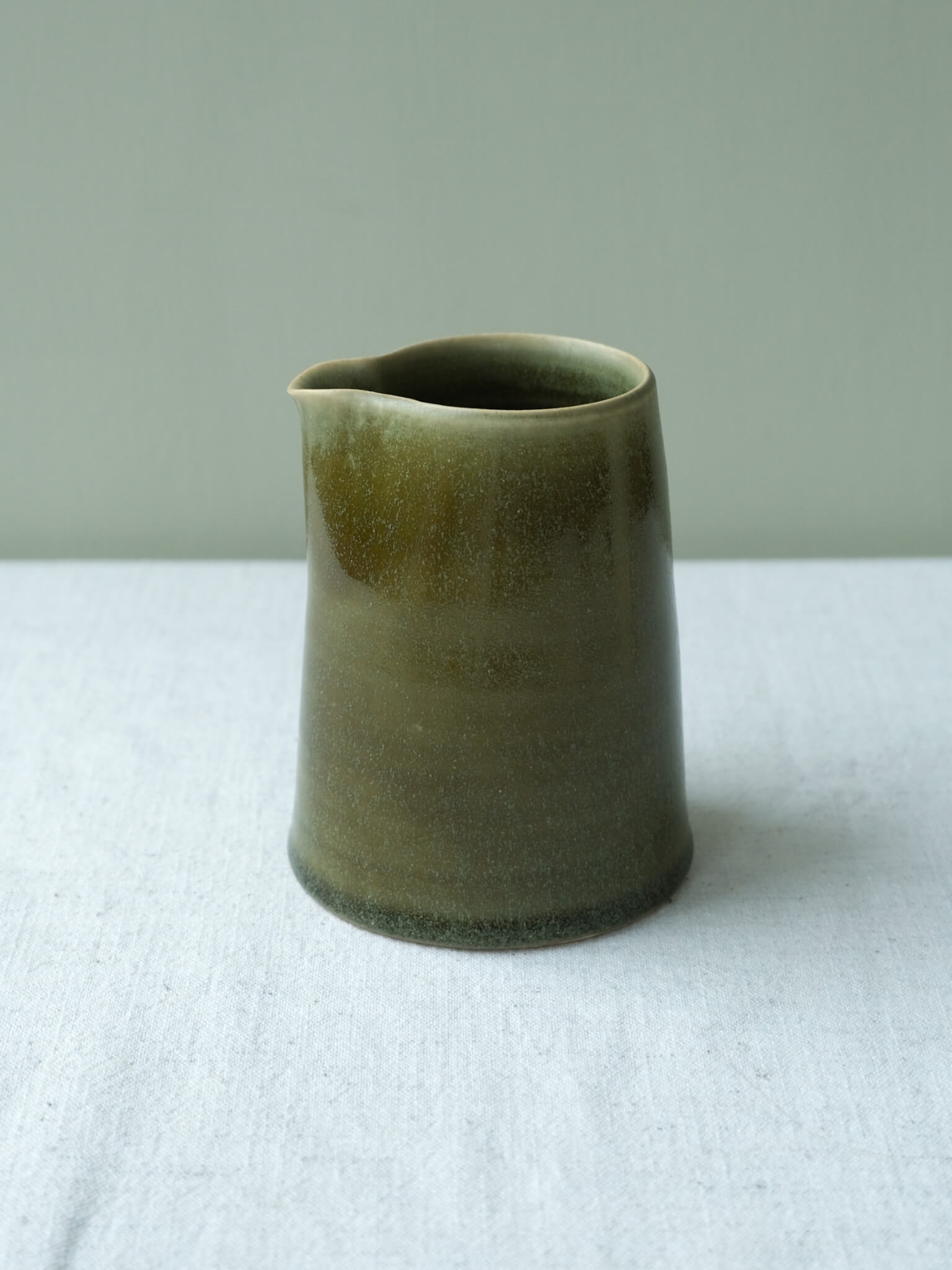 Ceramic milk jug with moss-green glaze, made by Sophia McEvoy
