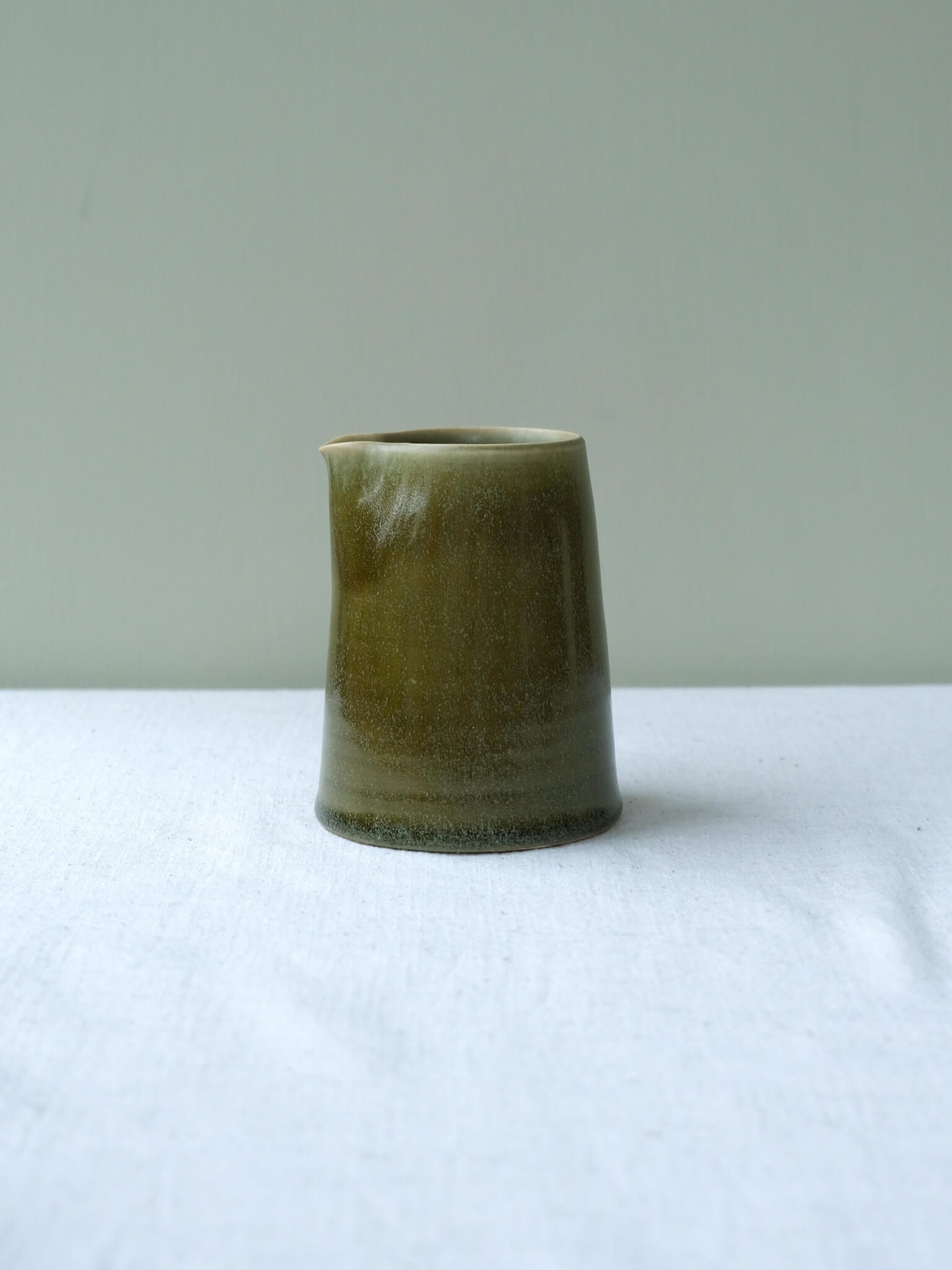 Ceramic milk jug with moss-green glaze, made by Sophia McEvoy